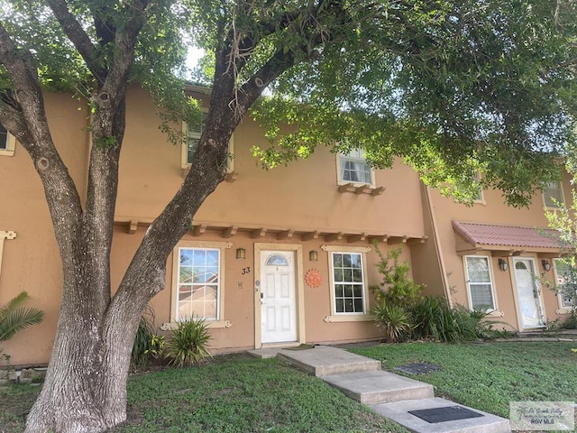2402 Ed Carey Dr Unit 33, Harlingen, TX 78550 - mediterranean / spanish-style home featuring a front yard and stucco siding