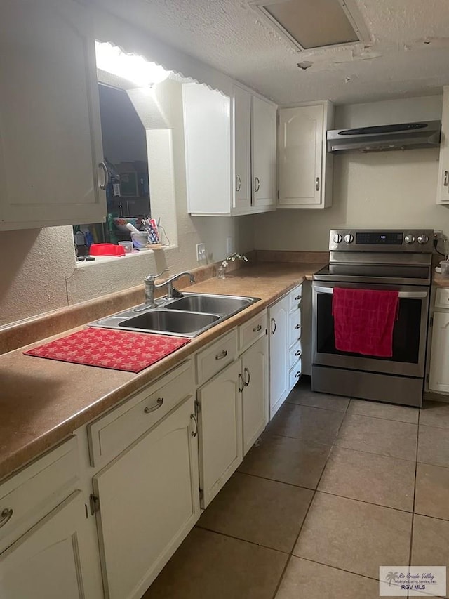 2402 Ed Carey Dr Unit 33, Harlingen, TX 78550 - kitchen with stainless steel electric stove, ventilation hood, white cabinetry, light tile patterned floors, and a textured ceiling
