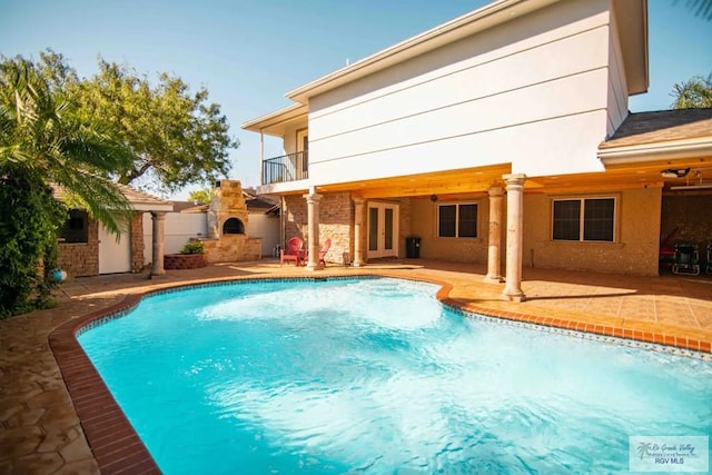 view of swimming pool with a patio and an outdoor fireplace