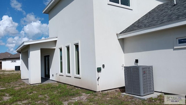 view of side of property with central air condition unit