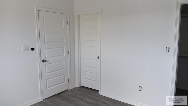 unfurnished bedroom with dark hardwood / wood-style flooring