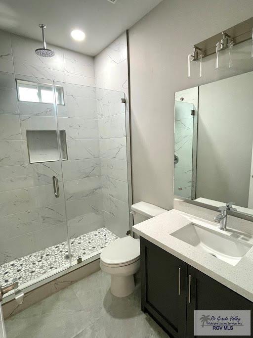 bathroom featuring vanity, toilet, and an enclosed shower