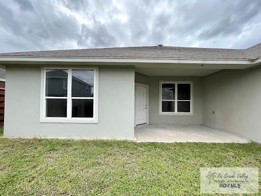 rear view of house featuring a yard and a patio area