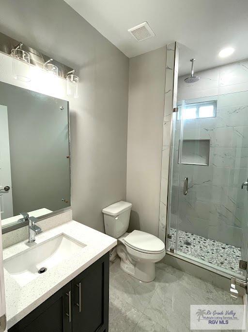 bathroom featuring vanity, toilet, and an enclosed shower