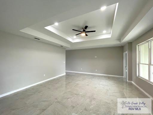 unfurnished room featuring a tray ceiling and ceiling fan