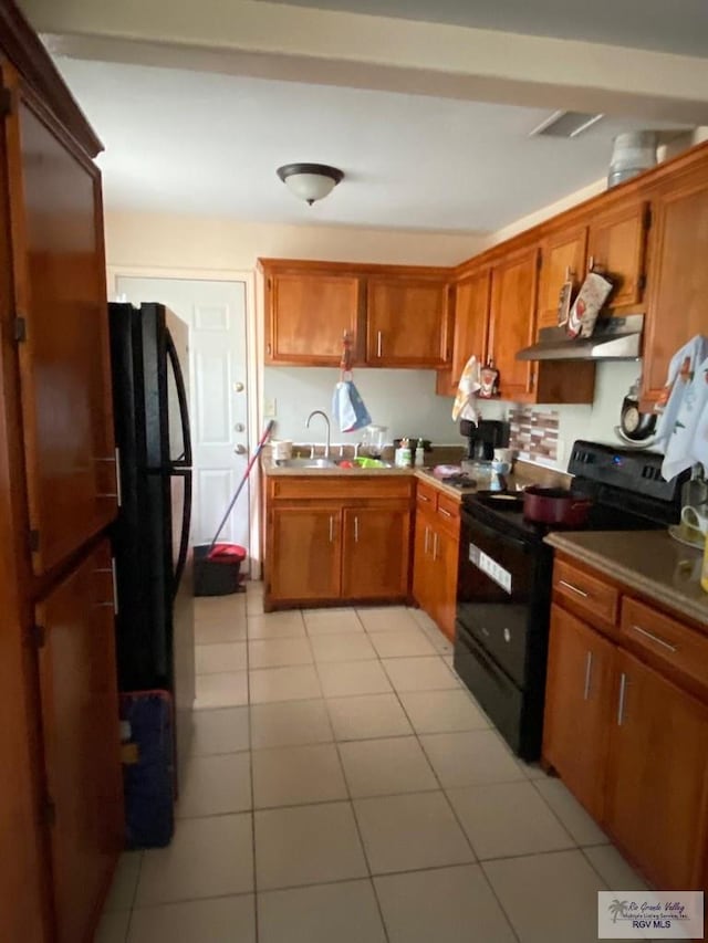 kitchen with sink, light tile patterned floors, and black appliances