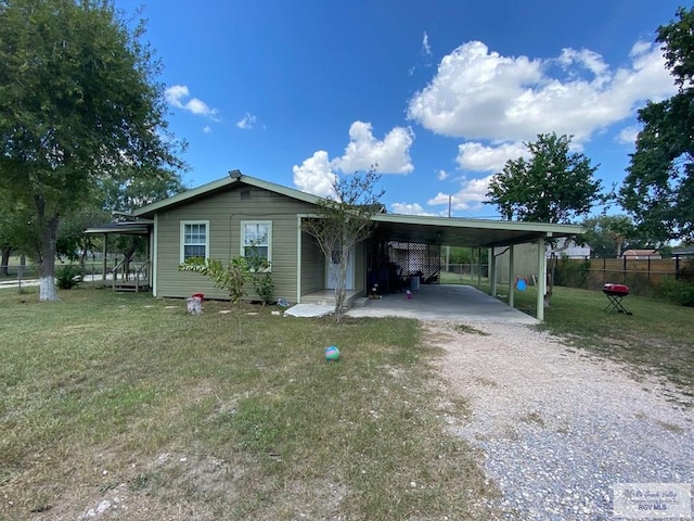 view of front of home with a carport and a front lawn