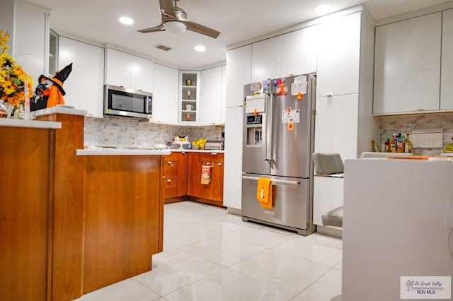 238 Starcrest Dr, Brownsville, TX 78521 - kitchen with stainless steel appliances, decorative backsplash, ceiling fan, light countertops, and glass insert cabinets