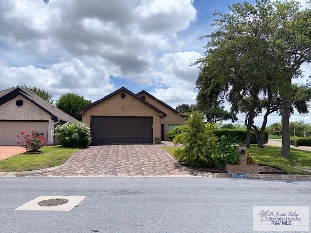 201 Terrace Ln, Harlingen, TX 78550 - ranch-style house featuring driveway, an attached garage, and a front lawn