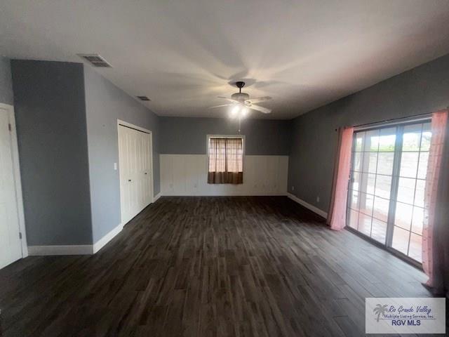 201 Terrace Ln, Harlingen, TX 78550 - spare room featuring dark wood finished floors, plenty of natural light, ceiling fan, and baseboards