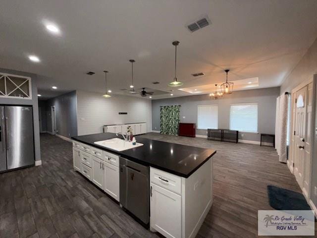 201 Terrace Ln, Harlingen, TX 78550 - kitchen featuring stainless steel appliances, dark countertops, a sink, dark wood finished floors, and recessed lighting