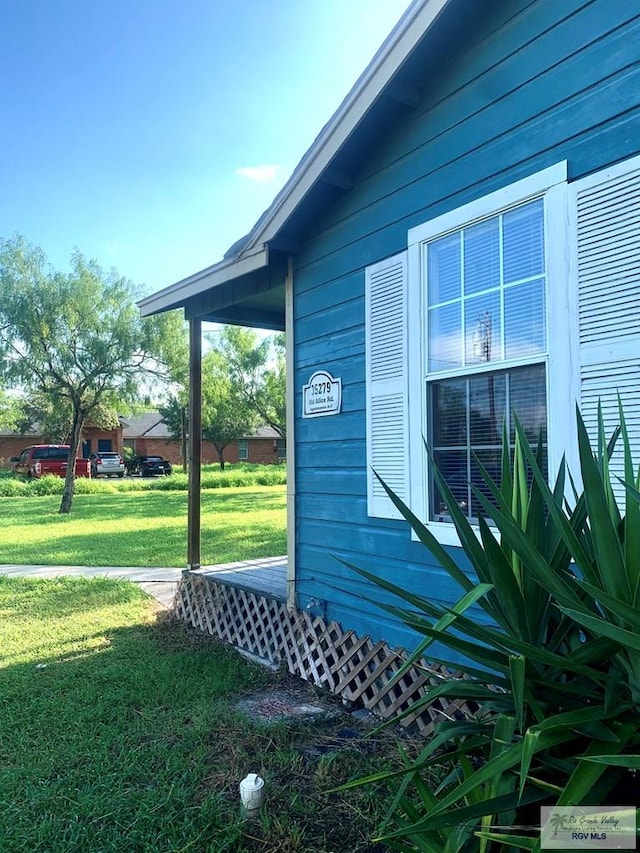 view of side of home with a yard