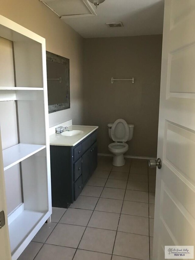 bathroom with tile patterned flooring, vanity, and toilet