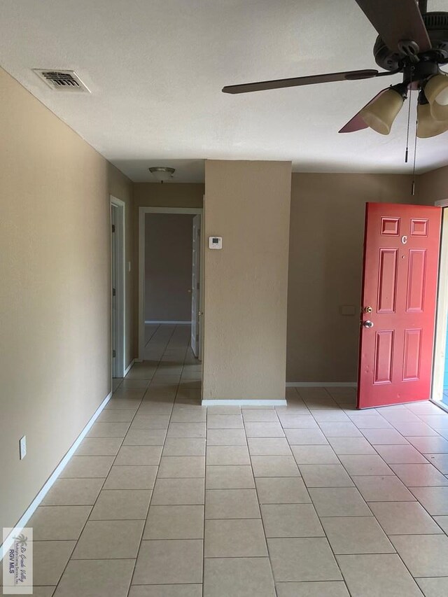 spare room featuring ceiling fan and light tile patterned flooring