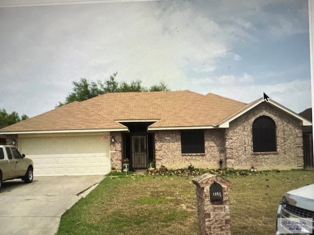 single story home featuring a front yard and a garage