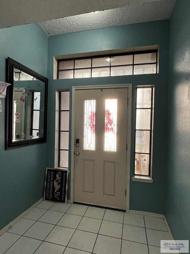 tiled foyer entrance with a textured ceiling