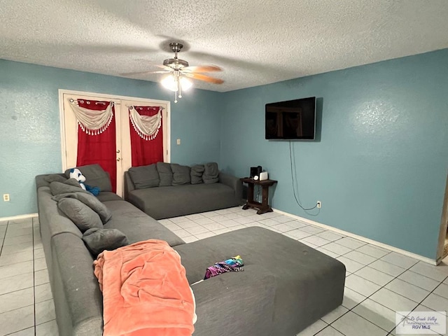 living room featuring a textured ceiling, light tile patterned flooring, and ceiling fan