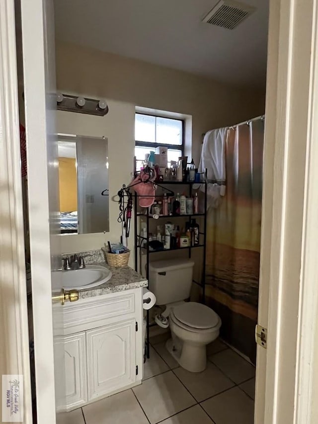 bathroom with toilet, tile patterned flooring, and vanity