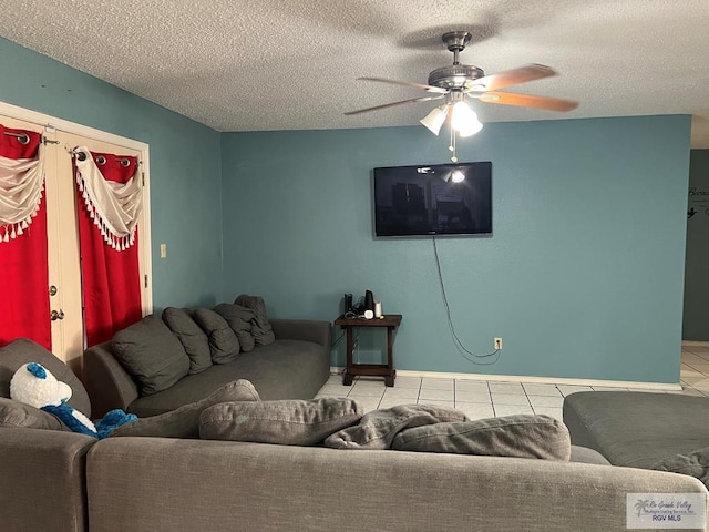 tiled living room with ceiling fan and a textured ceiling