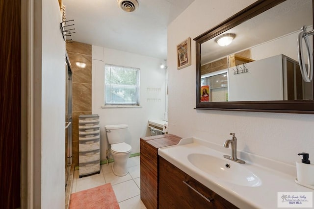full bath featuring visible vents, toilet, a shower with shower door, vanity, and tile patterned flooring