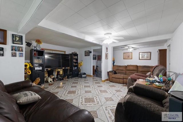 living area featuring beam ceiling, light tile patterned floors, and ceiling fan