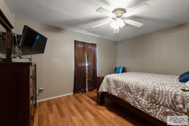bedroom featuring baseboards, a ceiling fan, and light wood-style flooring
