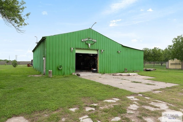 view of pole building with a lawn and concrete driveway