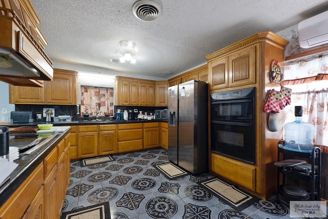 kitchen featuring a wall unit AC, visible vents, under cabinet range hood, black appliances, and backsplash