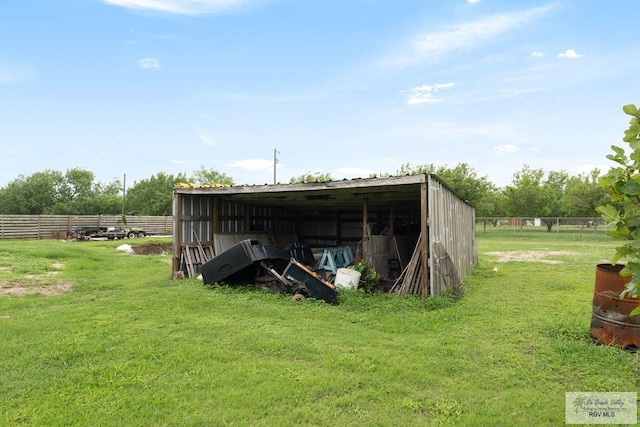 view of pole building featuring fence and a yard