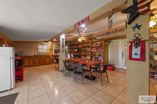 dining area featuring french doors, ceiling fan, a textured ceiling, and light tile patterned flooring