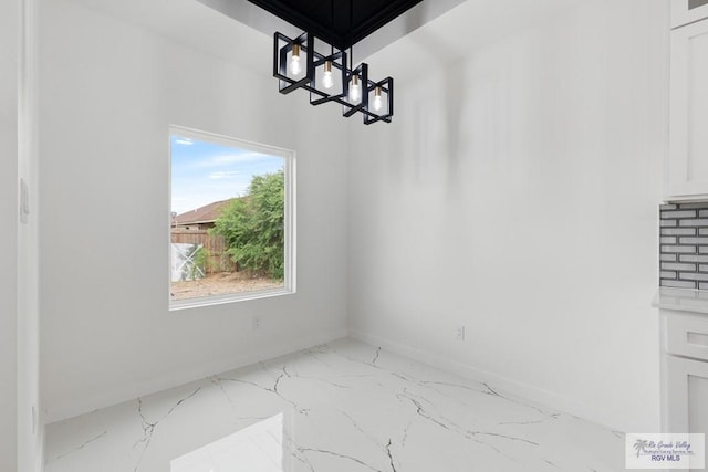 unfurnished dining area featuring an inviting chandelier