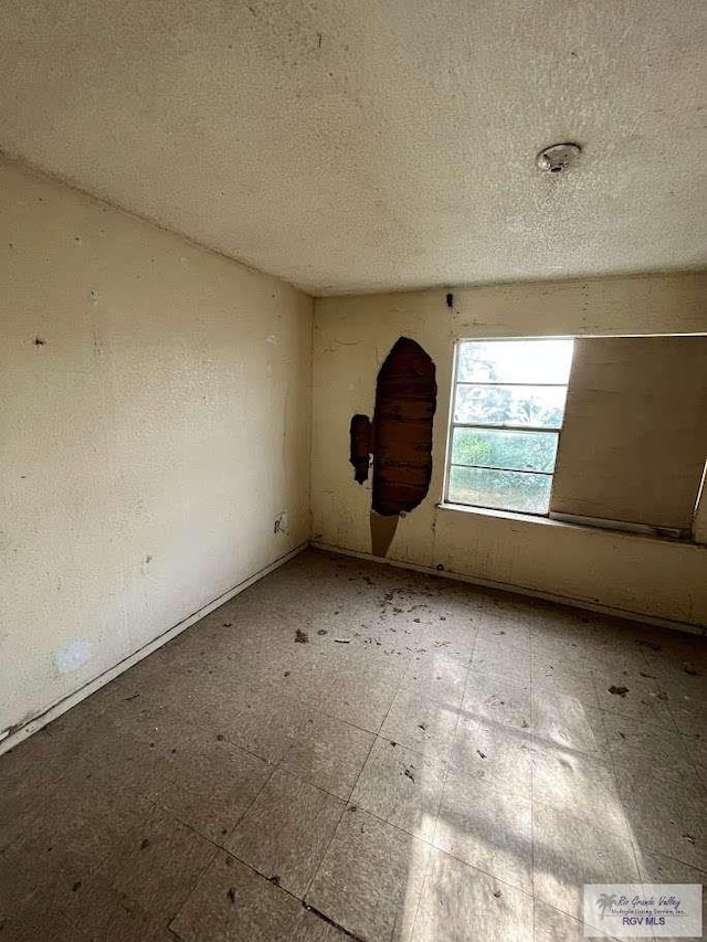 unfurnished room featuring a textured ceiling