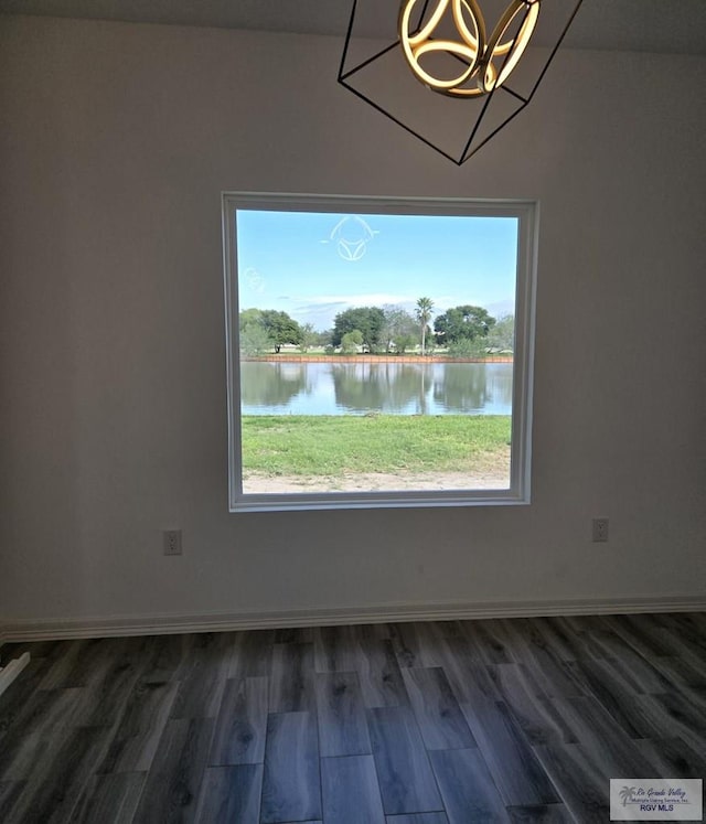 unfurnished dining area with dark hardwood / wood-style flooring, a water view, and plenty of natural light