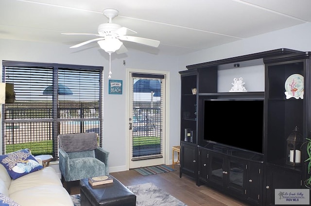 living room featuring ceiling fan and dark hardwood / wood-style floors