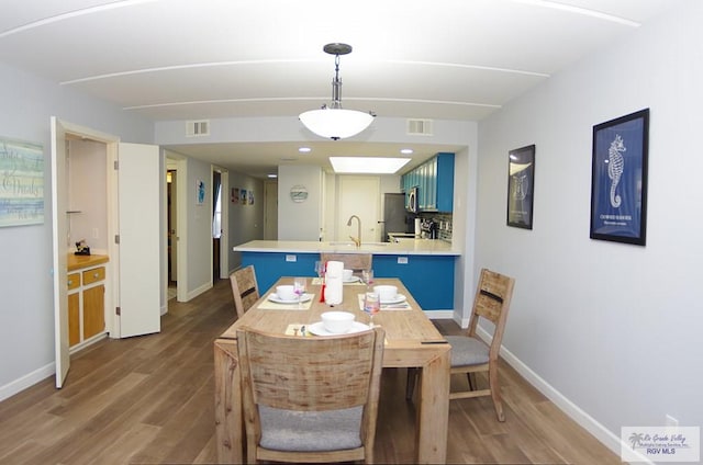 dining room with sink and hardwood / wood-style flooring