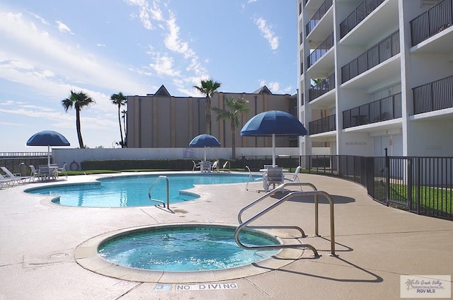 view of pool featuring a hot tub and a patio