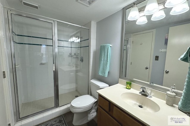 bathroom with vanity, toilet, and an enclosed shower