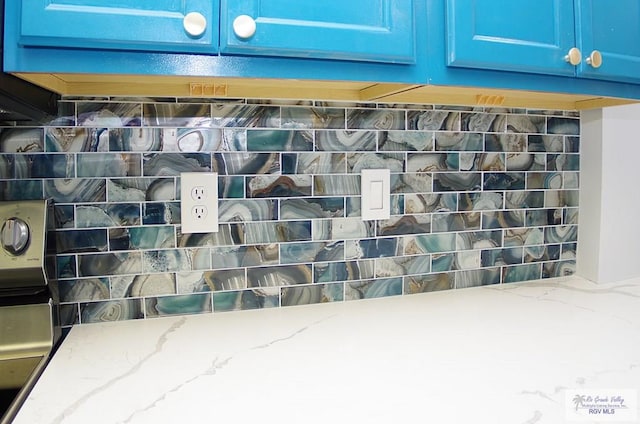 interior details with blue cabinetry and light stone counters