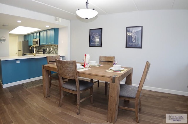 dining area with dark hardwood / wood-style floors and sink