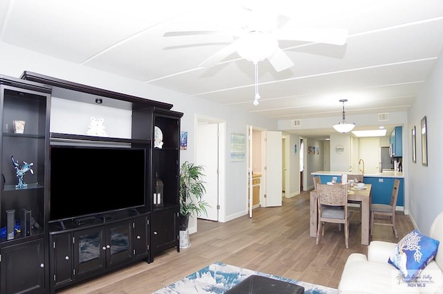 living room featuring ceiling fan and light hardwood / wood-style flooring