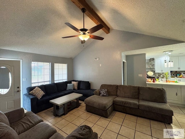 living room featuring ceiling fan, light tile patterned floors, a textured ceiling, and vaulted ceiling with beams