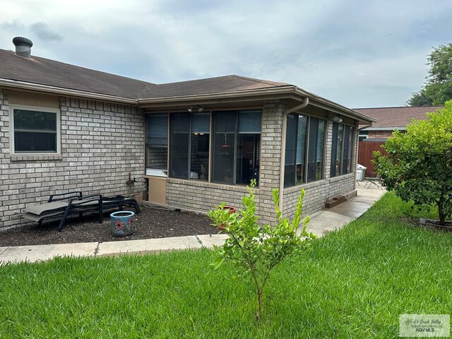 42 Cherokee Dr, Harlingen, TX 78550 - view of home's exterior featuring a sunroom and brick siding