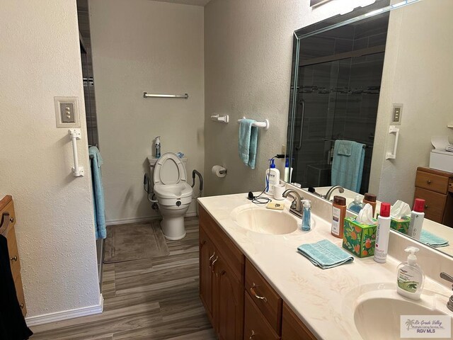 42 Cherokee Dr, Harlingen, TX 78550 - full bathroom with double vanity, toilet, a stall shower, baseboards, and a textured wall