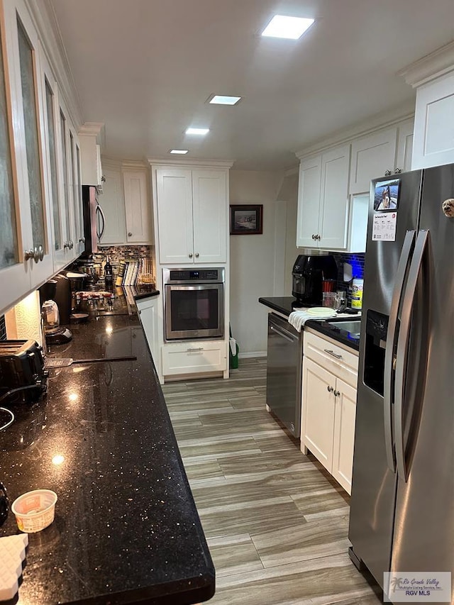 42 Cherokee Dr, Harlingen, TX 78550 - kitchen with appliances with stainless steel finishes, tasteful backsplash, white cabinetry, and dark stone countertops