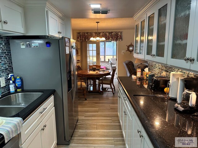 42 Cherokee Dr, Harlingen, TX 78550 - kitchen featuring a chandelier, tasteful backsplash, stainless steel fridge with ice dispenser, and light wood finished floors