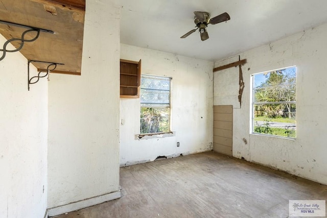 empty room with ceiling fan and plenty of natural light