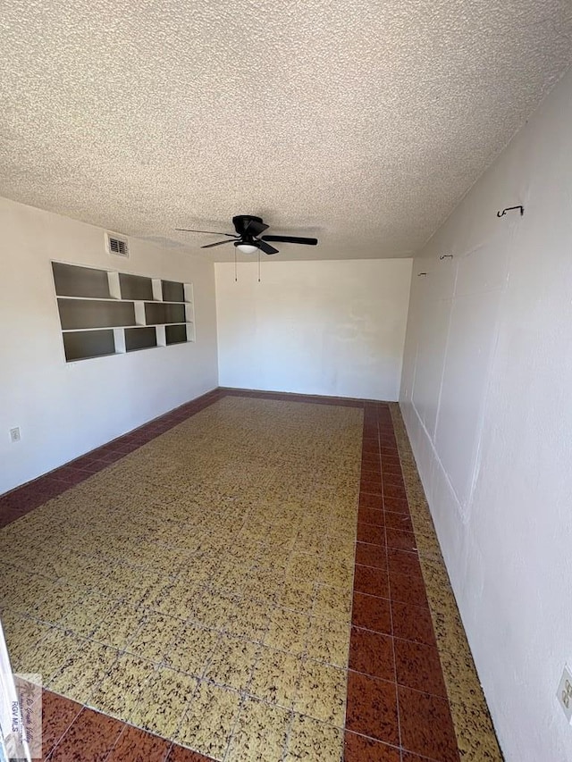unfurnished room featuring a textured ceiling, ceiling fan, and visible vents