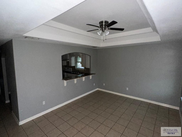 interior space with dark tile patterned floors and ceiling fan