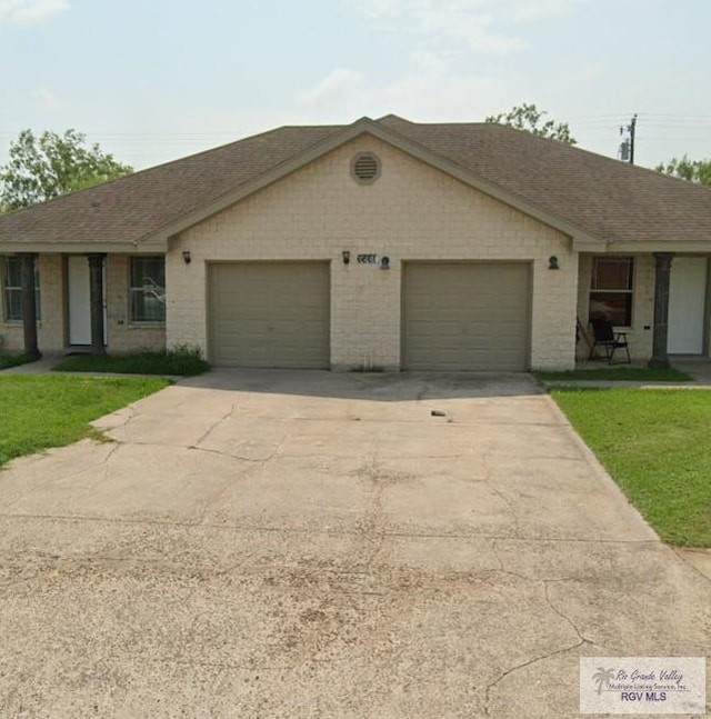 ranch-style home featuring a garage and a front lawn