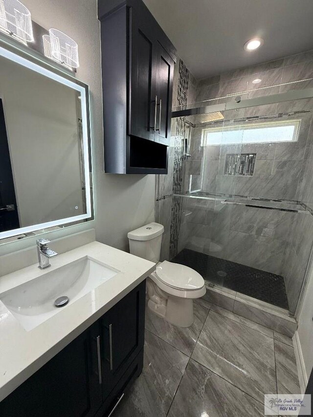 7377 San Andres St, Brownsville, TX 78520 - bathroom with toilet, vanity, a shower stall, marble look tiles, and recessed lighting